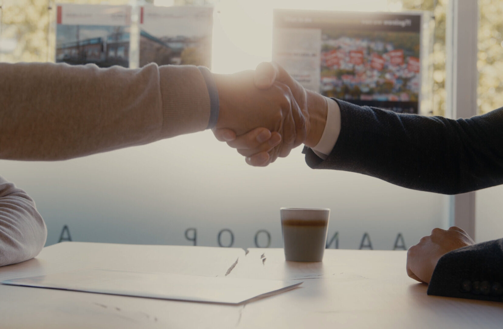 makelaar schudt hand van opdrachtgever na aankoop van bedrijfsaanbod